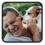Customer testimonial: smiling man with glasses as a Jack Russell licks his ear after using UltraK9 Pro.